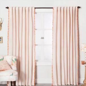 Two Blush curtains with orange tassles